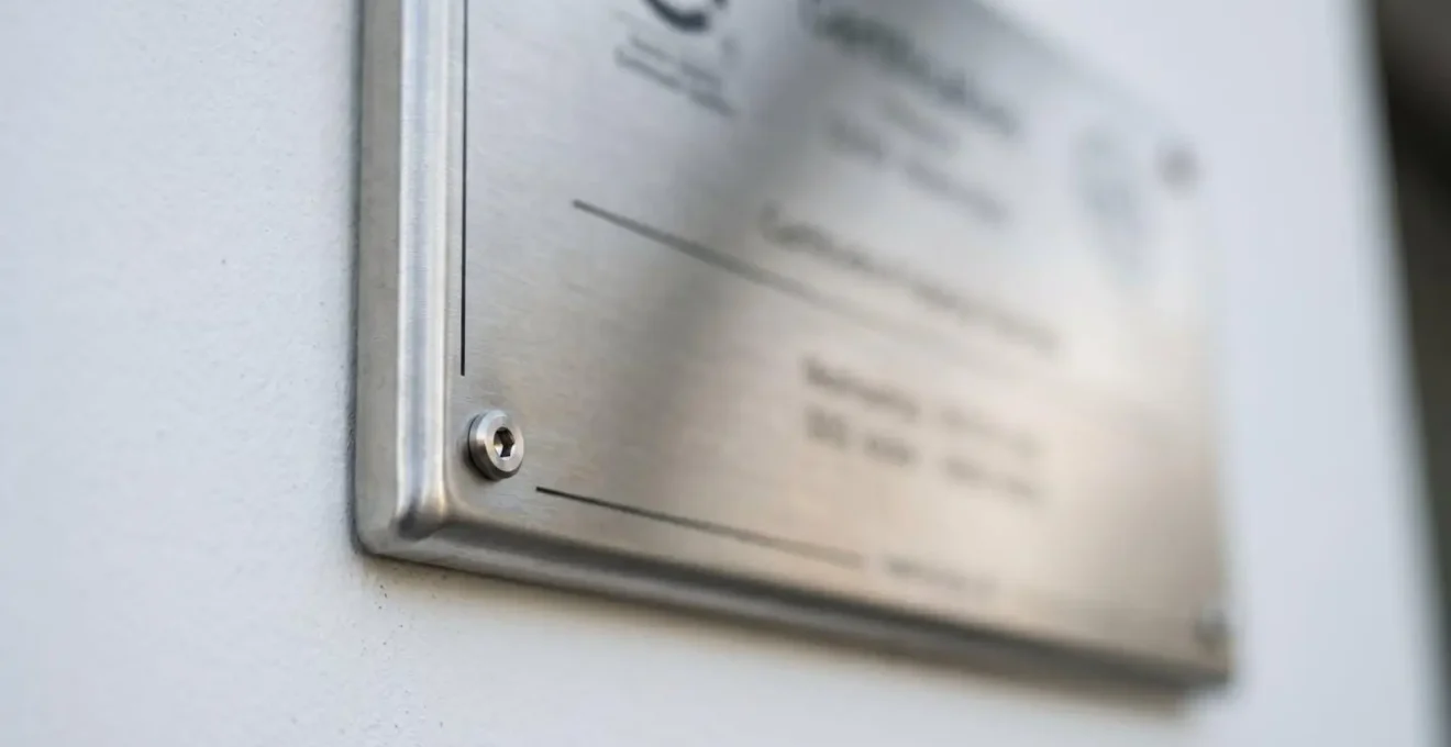 Gros plan sur une plaque métallique officielle de certification fixée sur un mur blanc immaculé dans une clinique contemporaine